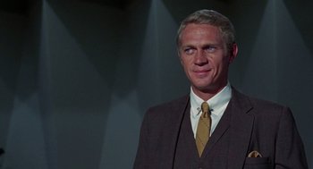 Movie still from “The Thomas Crown Affair” (1968), directed by Norman Jewison – A man in a suit and tie standing in front of a wall; Close Up shot, Over the shoulder angle