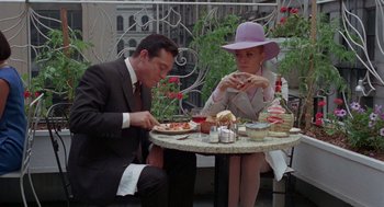 Movie still from “The Thomas Crown Affair” (1968), directed by Norman Jewison – A man and a woman sitting at a table eating pizza; Medium shot, High angle