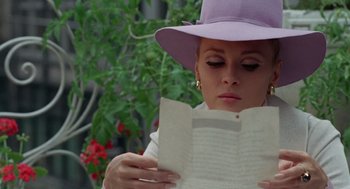 Movie still from “The Thomas Crown Affair” (1968), directed by Norman Jewison – A woman wearing a purple hat reading a book; Close Up shot, Over the shoulder angle