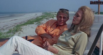 Movie still from “The Thomas Crown Affair” (1968), directed by Norman Jewison – A man and a woman sitting on the beach; Medium shot, Over the shoulder angle