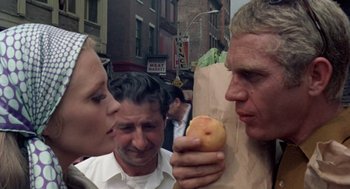 Movie still from “The Thomas Crown Affair” (1968), directed by Norman Jewison – A man holding an apple in his right hand while two women look on; Close Up shot, Over the shoulder angle