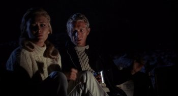 Movie still from “The Thomas Crown Affair” (1968), directed by Norman Jewison – A man and a woman sitting next to each other in the dark; Medium shot, Over the shoulder angle