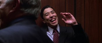 Movie still from “The Thomas Crown Affair” (1999), directed by John McTiernan – A man wearing a suit and tie laughing; Close Up shot, Low angle