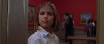 Movie still from “The Thomas Crown Affair” (1999), directed by John McTiernan – A young girl in a white shirt and a blue pin; Close Up shot, Low angle
