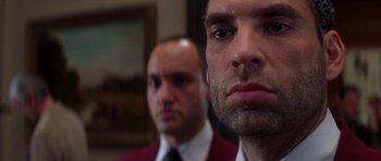 Movie still from “The Thomas Crown Affair” (1999), directed by John McTiernan – A man in a suit and tie standing next to another man in a suit and tie; Close Up shot, Low angle