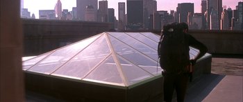Movie still from “The Thomas Crown Affair” (1999), directed by John McTiernan – A man standing on top of a building looking at the city; Wide shot, Low angle