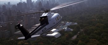 Movie still from “The Thomas Crown Affair” (1999), directed by John McTiernan – A helicopter flying in the sky over a large city; Wide shot, High angle