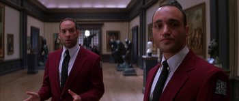 Movie still from “The Thomas Crown Affair” (1999), directed by John McTiernan – A couple of men standing next to each other in a room; Medium shot, Low angle