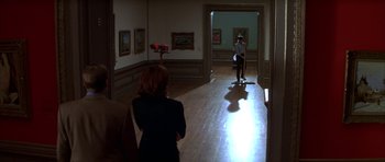 Movie still from “The Thomas Crown Affair” (1999), directed by John McTiernan – A woman standing in front of a painting in an art gallery; Wide shot, High angle