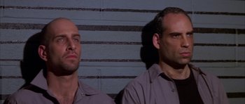 Movie still from “The Thomas Crown Affair” (1999), directed by John McTiernan – A couple of men standing next to each other; Close Up shot, Low angle