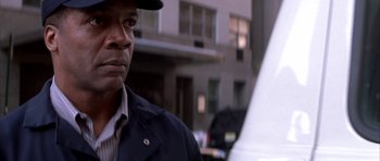 Movie still from “The Thomas Crown Affair” (1999), directed by John McTiernan – A person wearing a hat and a jacket; Close Up shot, Low angle