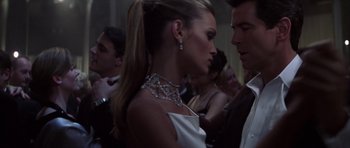 Movie still from “The Thomas Crown Affair” (1999), directed by John McTiernan – A woman in a white dress standing next to a man in a black suit; Close Up shot, Low angle
