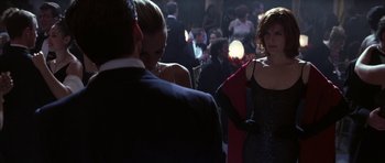 Movie still from “The Thomas Crown Affair” (1999), directed by John McTiernan – A group of people standing in a room; Medium shot, Over the shoulder angle