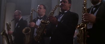 Movie still from “The Thomas Crown Affair” (1999), directed by John McTiernan – Two men in tuxedos holding saxophones in their hands; Medium shot, Low angle