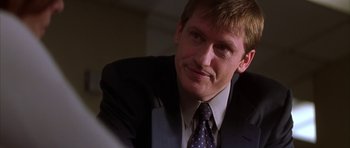 Movie still from “The Thomas Crown Affair” (1999), directed by John McTiernan – A person wearing a suit and tie; Close Up shot, Over the shoulder angle