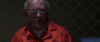 Movie still from “The Thomas Crown Affair” (1999), directed by John McTiernan – An older man wearing a red jacket and glasses; Close Up shot, Low angle