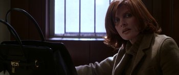 Movie still from “The Thomas Crown Affair” (1999), directed by John McTiernan – A woman sitting at a table with a laptop; Close Up shot, Low angle
