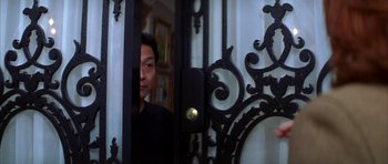 Movie still from “The Thomas Crown Affair” (1999), directed by John McTiernan – A man standing in front of an ornate iron gate; Close Up shot, Over the shoulder angle