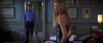 Movie still from “The Thomas Crown Affair” (1999), directed by John McTiernan – A woman in a black dress standing in front of a man; Medium shot, Over the shoulder angle