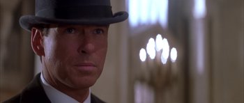 Movie still from “The Thomas Crown Affair” (1999), directed by John McTiernan – A person wearing a suit and a hat; Close Up shot, Over the shoulder angle