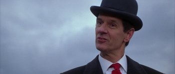 Movie still from “The Thomas Crown Affair” (1999), directed by John McTiernan – A person wearing a suit and a hat; Close Up shot, Low angle