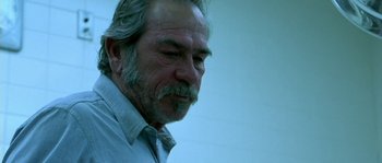 Movie still from “The Three Burials of Melquiades Estrada” (2005), directed by Tommy Lee Jones – An older man with a gray beard looking down; Close Up shot, Low angle