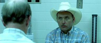 Movie still from “The Three Burials of Melquiades Estrada” (2005), directed by Tommy Lee Jones – A man in a cowboy hat sitting in front of another man; Close Up shot, Over the shoulder angle