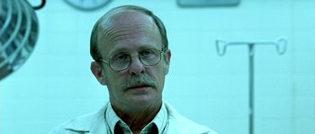 Movie still from “The Three Burials of Melquiades Estrada” (2005), directed by Tommy Lee Jones – An older man wearing a white lab coat and glasses; Close Up shot, Low angle