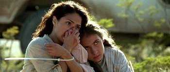 Movie still from “The Three Burials of Melquiades Estrada” (2005), directed by Tommy Lee Jones – Two young women holding hands and one covering her face; Close Up shot, Low angle