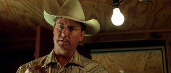 Movie still from “The Three Burials of Melquiades Estrada” (2005), directed by Tommy Lee Jones – A man wearing a cowboy hat and glasses; Close Up shot, Low angle