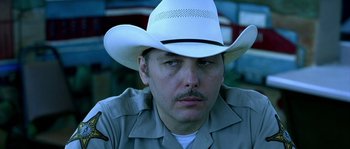 Movie still from “The Three Burials of Melquiades Estrada” (2005), directed by Tommy Lee Jones – A person wearing a cowboy hat; Close Up shot, Over the shoulder angle