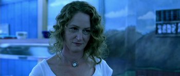Movie still from “The Three Burials of Melquiades Estrada” (2005), directed by Tommy Lee Jones – A person with curly hair wearing a necklace; Close Up shot, Low angle