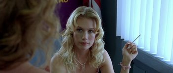 Movie still from “The Three Burials of Melquiades Estrada” (2005), directed by Tommy Lee Jones – A woman with blonde curly hair wearing a necklace; Close Up shot, Over the shoulder angle