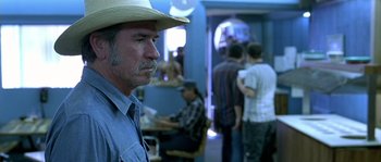 Movie still from “The Three Burials of Melquiades Estrada” (2005), directed by Tommy Lee Jones – An older man with a straw hat is looking at the camera; Close Up shot, Over the shoulder angle