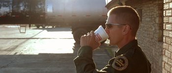 Movie still from “The Three Burials of Melquiades Estrada” (2005), directed by Tommy Lee Jones – A man drinking a cup of coffee while standing next to a truck; Close Up shot, Low angle