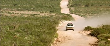 Movie still from “The Three Burials of Melquiades Estrada” (2005), directed by Tommy Lee Jones – A truck driving down a dirt road in the middle of the desert; Extreme Wide shot, High angle