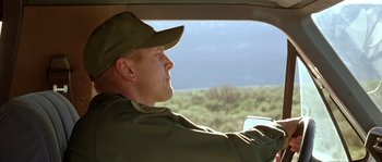 Movie still from “The Three Burials of Melquiades Estrada” (2005), directed by Tommy Lee Jones – A man in a hat driving a car in a field; Close Up shot, Low angle
