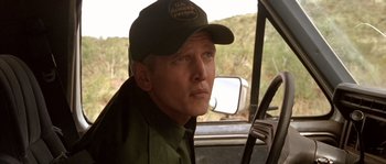Movie still from “The Three Burials of Melquiades Estrada” (2005), directed by Tommy Lee Jones – A man wearing a hat sitting in the driver's seat of a car; Close Up shot, Over the shoulder angle