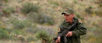 Movie still from “The Three Burials of Melquiades Estrada” (2005), directed by Tommy Lee Jones – A man holding a gun in his hand; Medium shot, Low angle