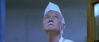 Movie still from “The Three Burials of Melquiades Estrada” (2005), directed by Tommy Lee Jones – An older man wearing a paper hat looking upward; Close Up shot, Low angle