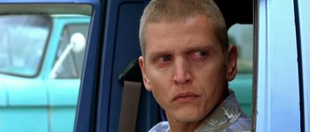 Movie still from “The Three Burials of Melquiades Estrada” (2005), directed by Tommy Lee Jones – A person with a shaved head; Close Up shot, Over the shoulder angle