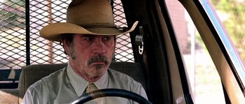 Movie still from “The Three Burials of Melquiades Estrada” (2005), directed by Tommy Lee Jones – A man in a hat sitting in the driver's seat of a car; Close Up shot, Over the shoulder angle