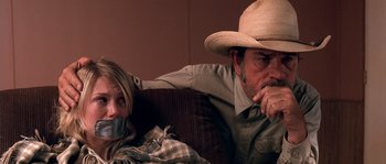Movie still from “The Three Burials of Melquiades Estrada” (2005), directed by Tommy Lee Jones – A man and a woman sitting next to each other on a couch; Close Up shot, Over the shoulder angle