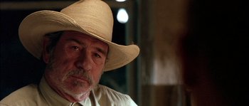 Movie still from “The Three Burials of Melquiades Estrada” (2005), directed by Tommy Lee Jones – An older man wearing a straw cowboy hat; Close Up shot, Low angle