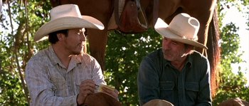 Movie still from “The Three Burials of Melquiades Estrada” (2005), directed by Tommy Lee Jones – Two men sitting next to each other in cowboy hats; Close Up shot, Over the shoulder angle