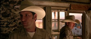 Movie still from “The Three Burials of Melquiades Estrada” (2005), directed by Tommy Lee Jones – A man wearing a cowboy hat in front of a window; Close Up shot, Over the shoulder angle