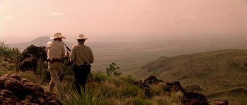 Movie still from “The Three Burials of Melquiades Estrada” (2005), directed by Tommy Lee Jones – A man standing on top of a hill looking out at a valley; Extreme Wide shot, Low angle