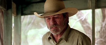 Movie still from “The Three Burials of Melquiades Estrada” (2005), directed by Tommy Lee Jones – An older man wearing a straw hat and a beige shirt; Close Up shot, Low angle