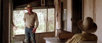 Movie still from “The Three Burials of Melquiades Estrada” (2005), directed by Tommy Lee Jones – A man standing in front of an open window; Medium shot, Low angle