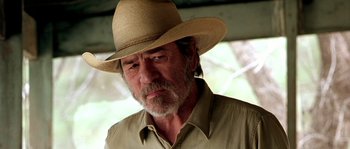 Movie still from “The Three Burials of Melquiades Estrada” (2005), directed by Tommy Lee Jones – An older man wearing a straw hat and shirt; Close Up shot, Low angle
